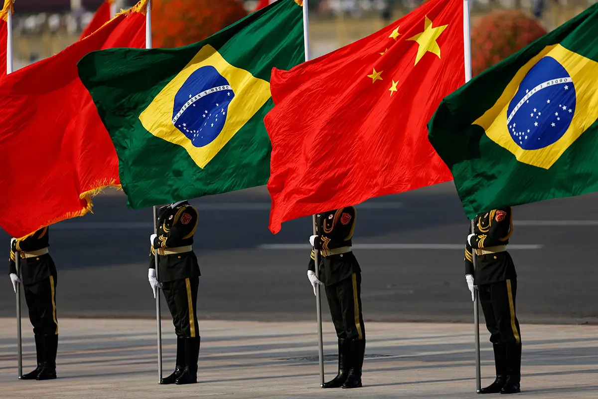 Honor guard holding Brazilian and Chinese flags during a diplomatic ceremony